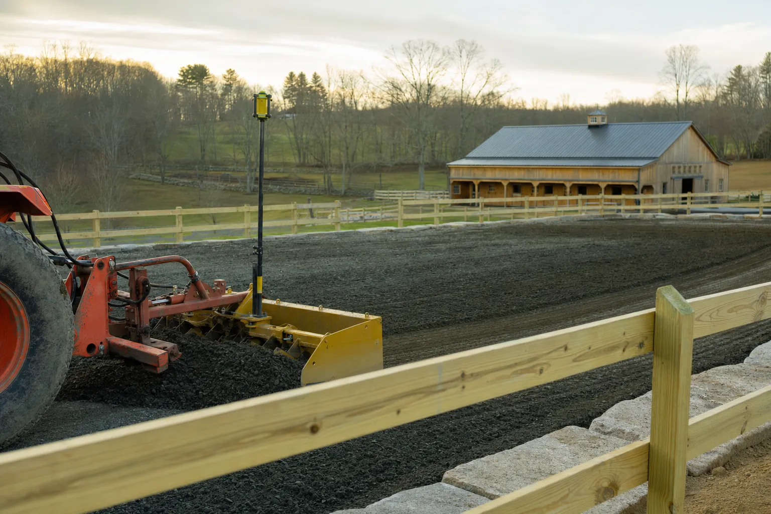 Newly built outdoor riding arena with a compacted stone base on a New England horse farm